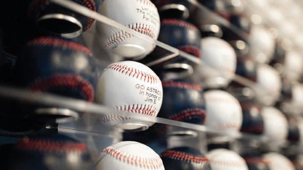 Rows of engraved white baseballs mounted on a display wall at another athletic facility
