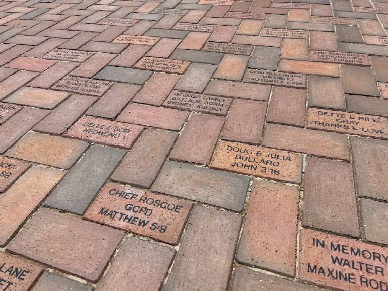 Engraved commemorative bricks in a walkway at another facility